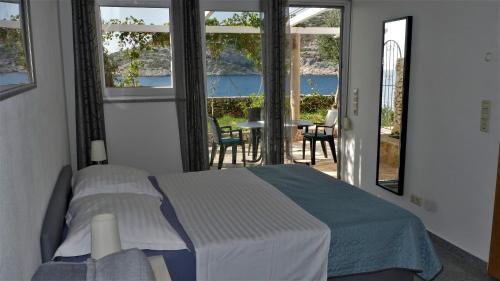 a bedroom with a bed and a view of the ocean at Apartments puntaplanka direkt am meer in Ražanj
