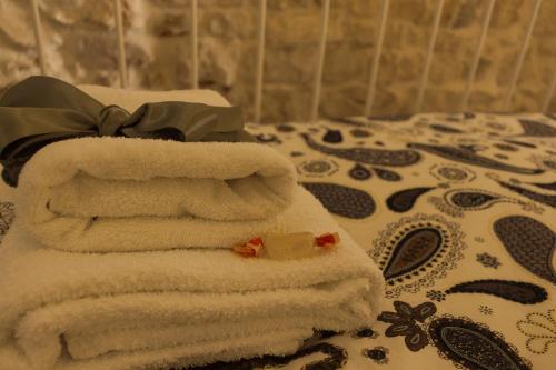 una pila de toallas sentadas encima de una cama en Il Sottano del Conte, en Conversano