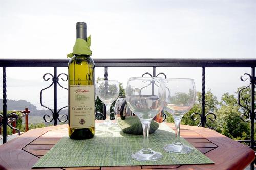a bottle of wine and two wine glasses on a table at Apartments Oktopus in Sutomore