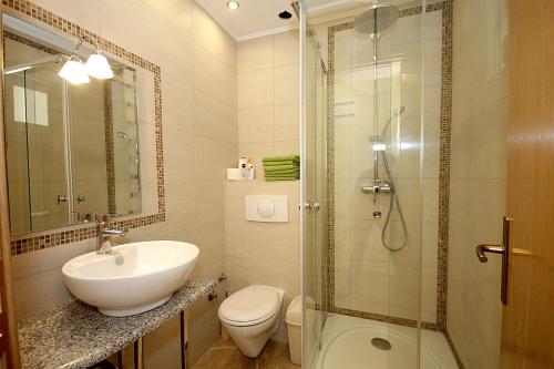 a bathroom with a sink and a toilet and a shower at Apartments Oktopus in Sutomore