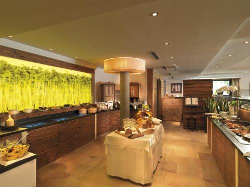 a large kitchen with a table in the middle at Hotel Kaprunerhof in Kaprun