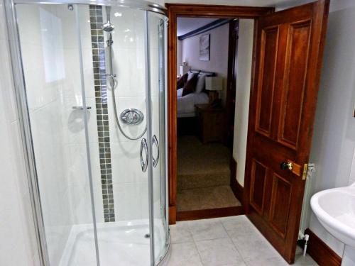a bathroom with a shower and a sink at Stocks Hotel in Sark
