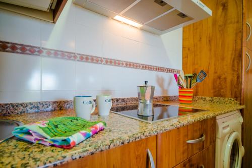 cocina con encimera con fregadero y fogones en Apartamento Levante, en Conil de la Frontera