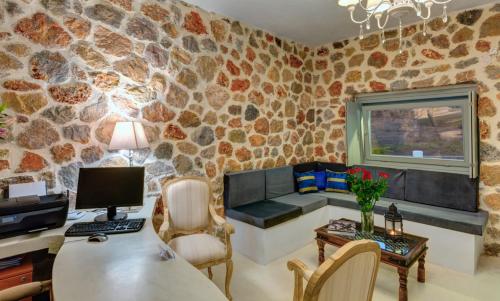 a living room with a stone wall at Desiterra Resort & Spa in Fira
