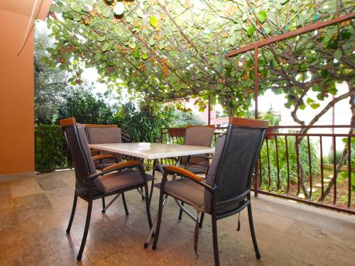 a table and chairs on a patio with a tree at Apartments Angela 1001 in Fažana