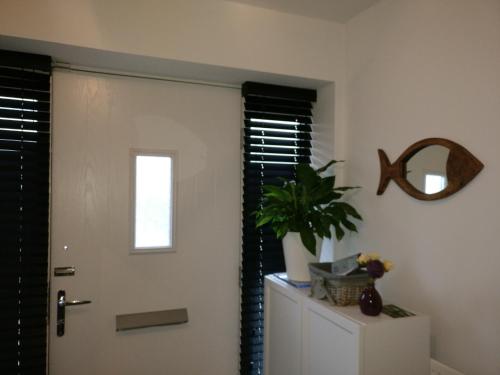 a door in a room with a plant on a cabinet at Arena House in Manchester