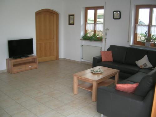 a living room with a couch and a tv at Ferienwohnung Familie Sinn in Pappenheim