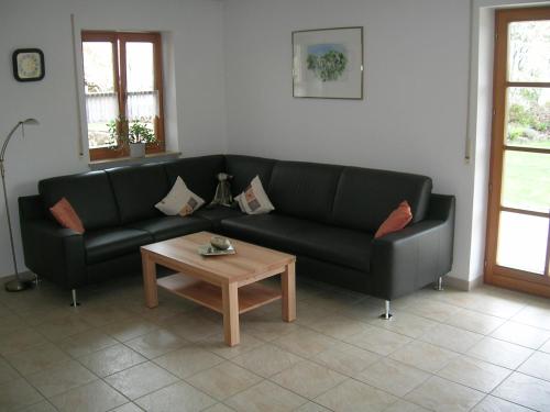 a living room with a black couch and a coffee table at Ferienwohnung Familie Sinn in Pappenheim