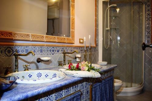 a bathroom with a sink and a tub with flowers on it at L’altra Sicilia…da Amare in Acquedolci