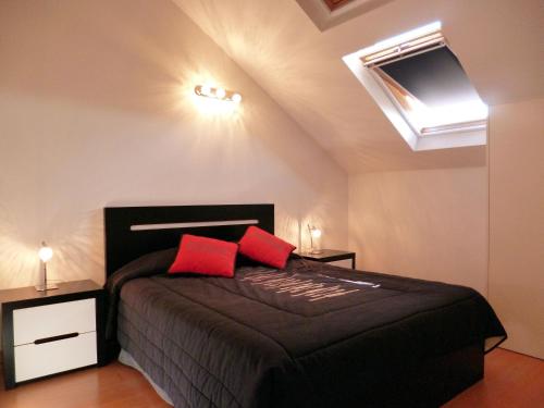 フンシャルにあるLuxury Apartment Living Funchalのベッドルーム1室(黒いベッド1台、赤い枕2つ付)