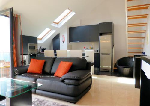 a living room with a black couch and a kitchen at Luxury Apartment Living Funchal in Funchal