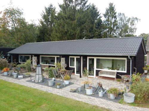 a black house with potted plants in front of it at De Rolders in Wapenveld