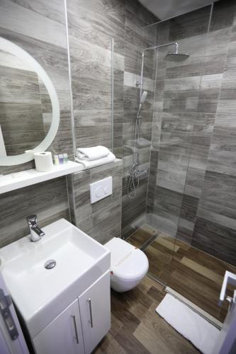 a bathroom with a sink, toilet and bathtub at Hotel Boutique Libris in Sarajevo