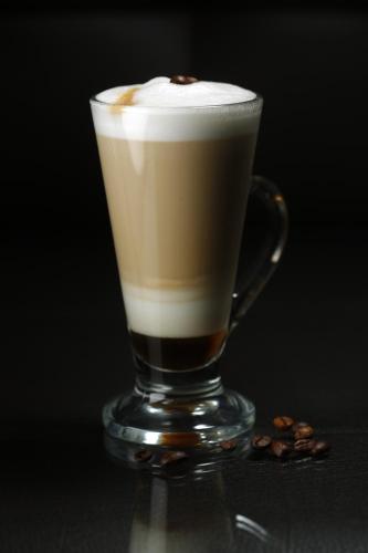 a glass of coffee sitting on a table at Central Hotel Yerevan in Yerevan