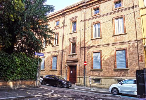 two cars parked in front of a large brick building at Bed & Breakfast Margherita in Bologna