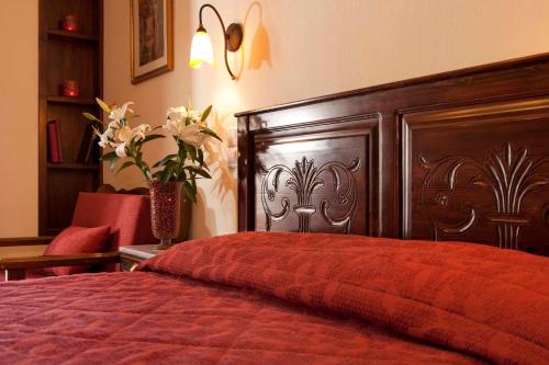 een slaapkamer met een groot houten bed met een rode sprei bij Fretzato in Elati Trikalon