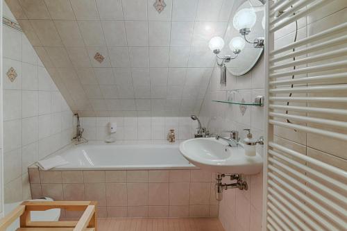 a bathroom with a bath tub and a sink at Seehotel Schorfheide in Althüttendorf