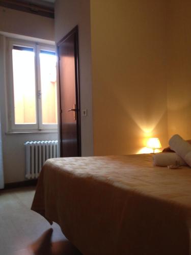 a bedroom with a bed with a lamp next to a window at Hotel Loreto in Loreto