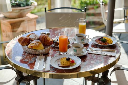 een tafel met een ontbijt van muffins en jus d'orange bij Villa Olmi Firenze in Florence