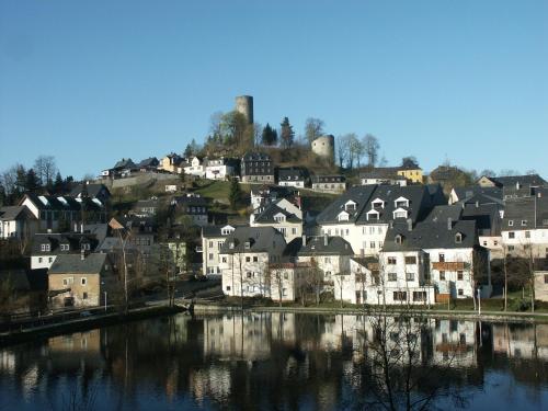 a group of houses on a hill next to a river at Pension Antik in Bad Lobenstein