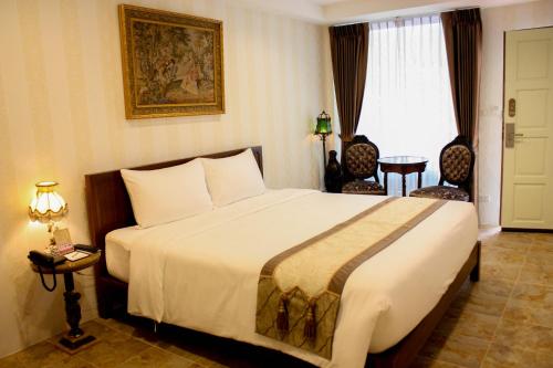 a hotel room with a large bed and a window at Chuchaiburi Sri Amphawa in Amphawa