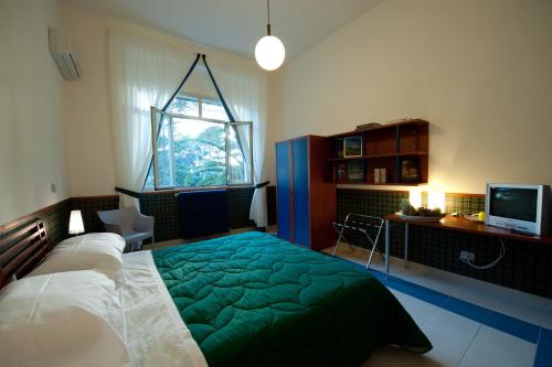1 dormitorio con 1 cama con manta verde en Hotel Villa Sturzo, en Caltagirone