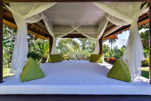 a bed in a tent with a white canopy at Villa Boutiq in Lovina