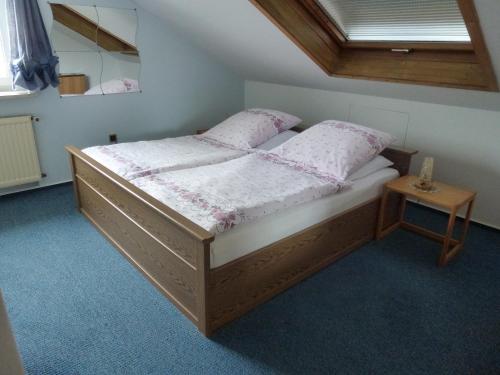 a bedroom with a wooden bed with white sheets and pillows at Haus Jägersruh in Nagel