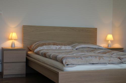 a bed with two nightstands and two lamps at Villa Tatranit in Nová Lesná