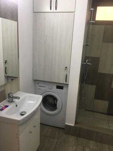 a bathroom with a washing machine and a sink at Apartament central V&P in Sibiu