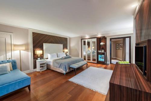 a bedroom with a bed and a blue couch at Elite World Istanbul Florya in Istanbul
