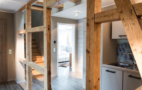 une cuisine et un escalier aménagés en mezzanine dans une petite maison dans l'établissement StrandBerg's Stadt Chalet, à Braunlage