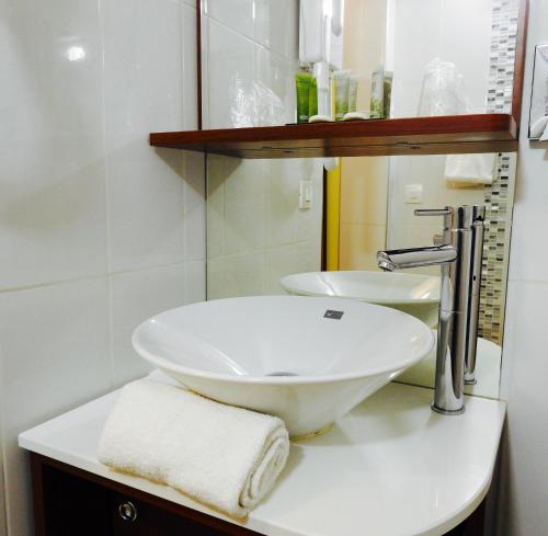 y baño con lavabo blanco y espejo. en Massilia hôtel en Marsella
