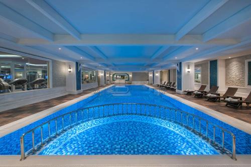 uma grande piscina no átrio do hotel, com uma grande piscina e um visor de piscina. em Elite World Istanbul Florya em Istambul