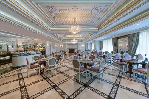 a dining room with tables and chairs and a chandelier at Elite World Business Hotel in Istanbul