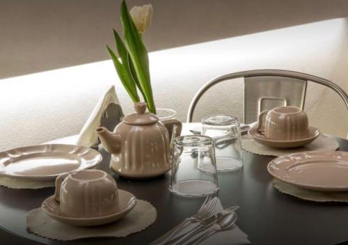 a table with plates and utensils and a tea kettle at Accademia 21 in Mantova