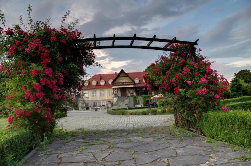 an arch with flowers in front of a building at Zespół Pałacowo-Parkowy Bądzów in Polkowice