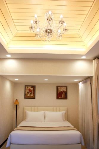 a bedroom with a bed and a chandelier at Chuchaiburi Sri Amphawa in Amphawa