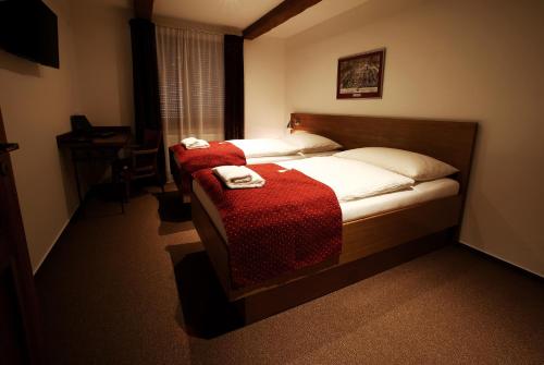 a bedroom with a bed with two towels on it at Apartments & Suites Žlutá Hruška in Plzeň