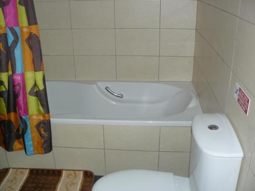 a bathroom with a toilet and a bath tub at Pyla Gardens E107 in Pyla