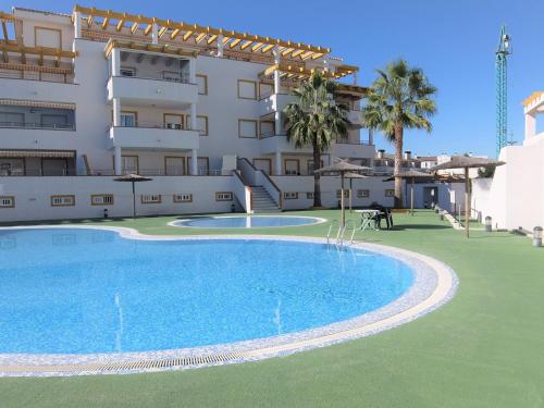 a large apartment with a swimming pool in front of a building at Poligono - Playa San Fernando in Oliva