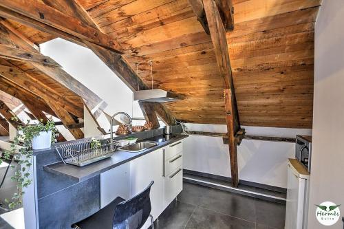 a kitchen with wooden ceilings and a sink at Hermès Suite in Salerno
