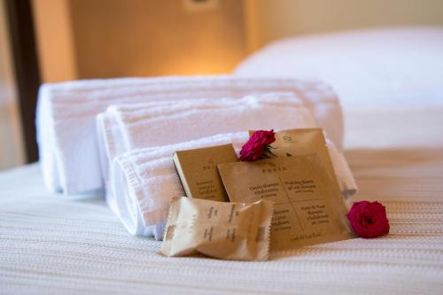 a pile of towels and flowers on a bed at Domus Il Palio in Siena