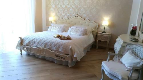a bedroom with a white bed with two shoes on it at La Valinfiore Charming Home in Montecarlo