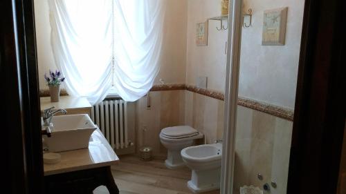 a bathroom with a toilet and a sink and a window at La Valinfiore Charming Home in Montecarlo