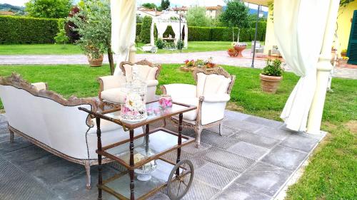 a patio with two chairs and a cart with a table at La Valinfiore Charming Home in Montecarlo