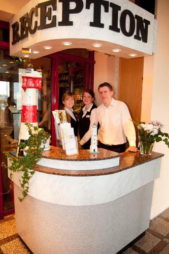 a group of people standing at a counter in a restaurant at Hotel Gremersdorf - Zum Grünen Jäger in Gremersdorf