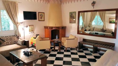 a living room with a fireplace and a mirror at Riad Dar Sofian in Zagora