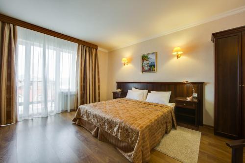 a hotel room with a bed and a large window at Anapa Lazurnaya Hotel in Anapa