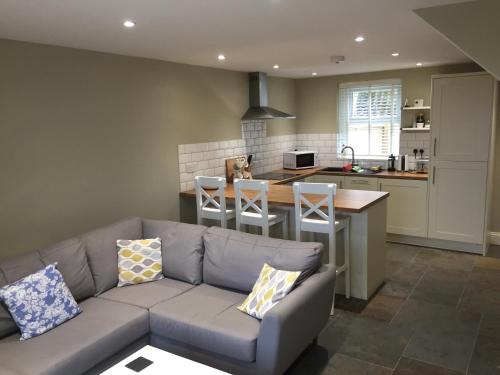 a living room with a couch and a kitchen at White House Cottages in Durham